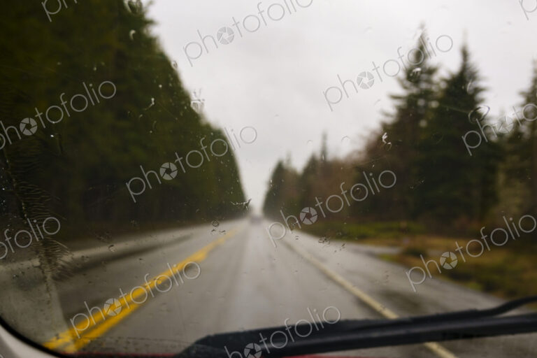 Driver's view through windshield of wet highway in rural area, WA, USA