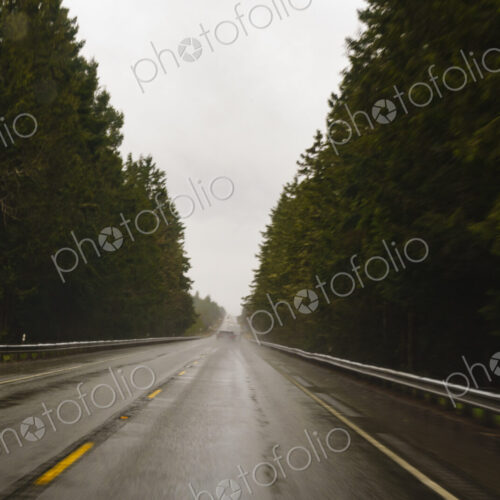 Driver's view through windshield of wet highway in rural area, WA, USA