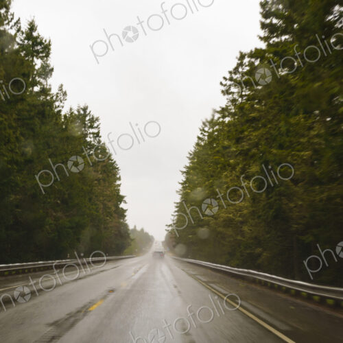 Driver's view through windshield of wet highway in rural area, WA, USA