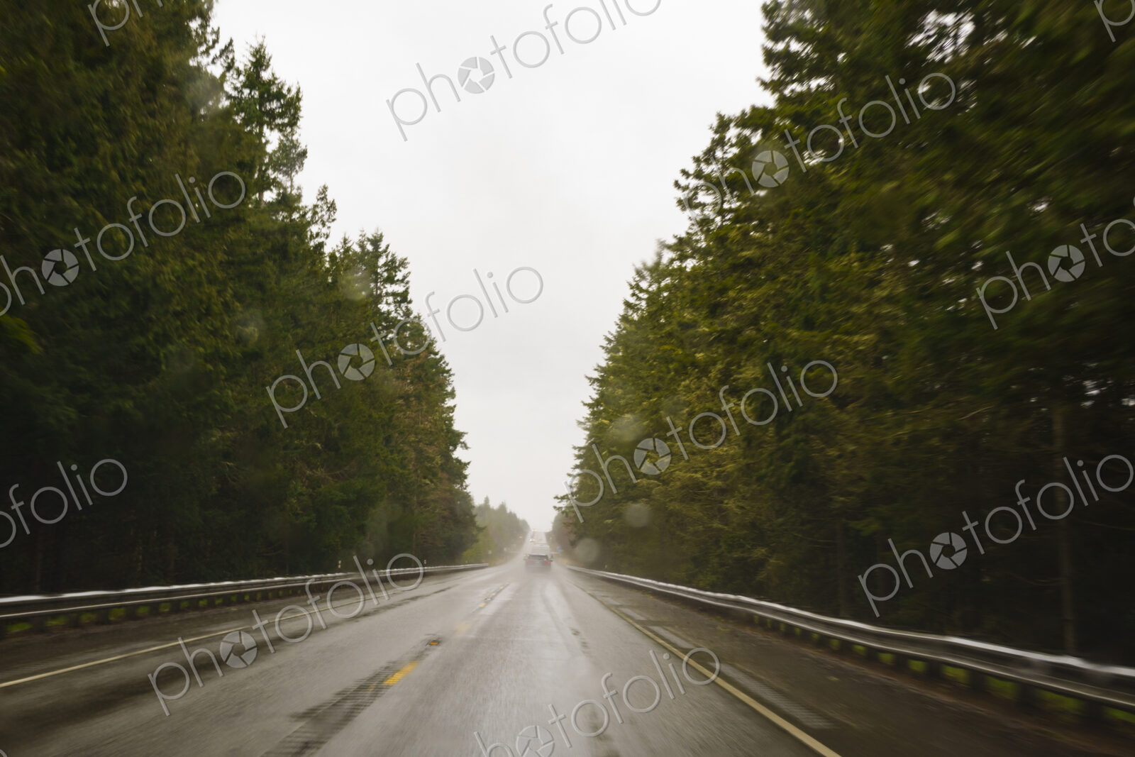 Driver’s view through windshield of wet highway in rural area, WA, USA