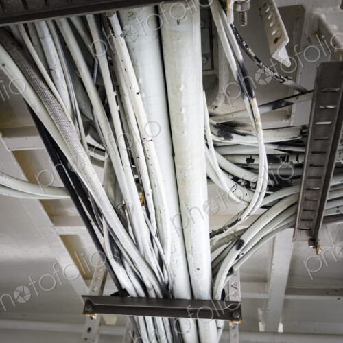 Electrical cables running along the ceiling of a ferry cabin ceiling, the wiring on a…