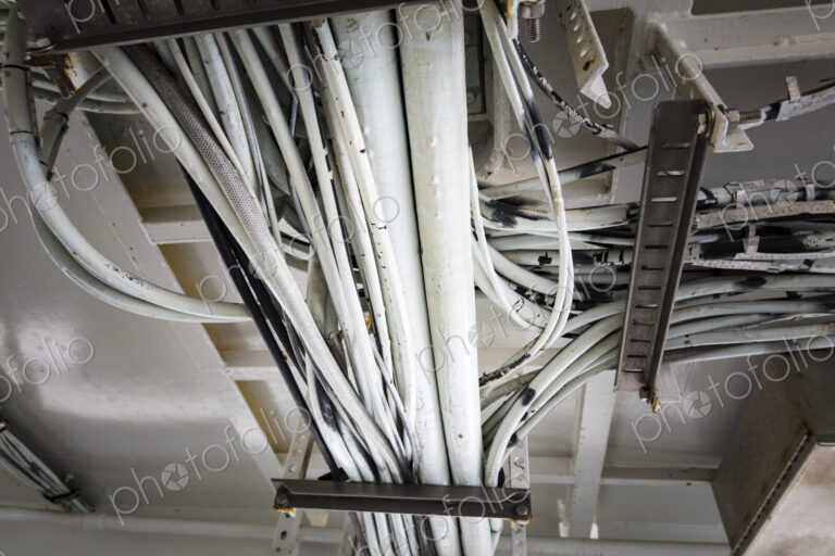 Electrical cables running along the ceiling of a ferry cabin ceiling, the wiring on a…