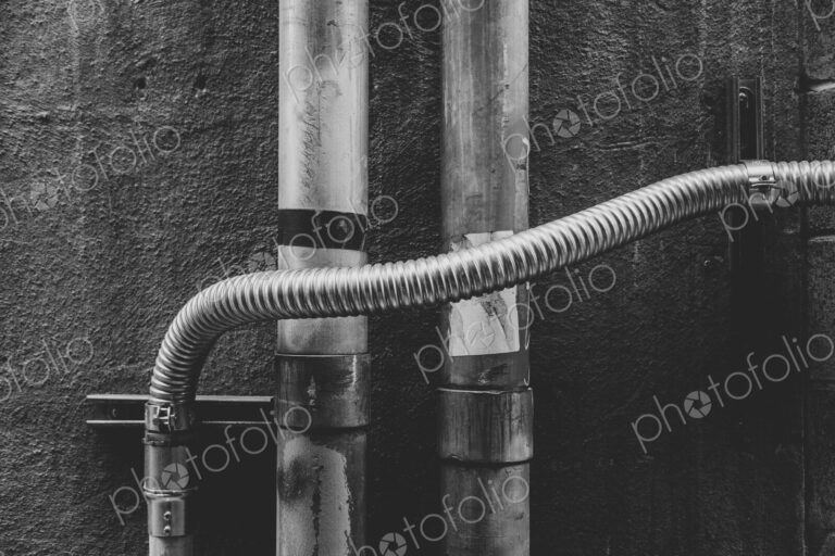 Electrical piping against building wall
