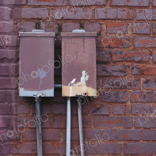 Electrical transmission boxes against painted brickwork.