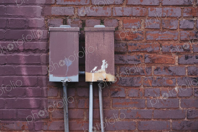 Electrical transmission boxes against painted brickwork.