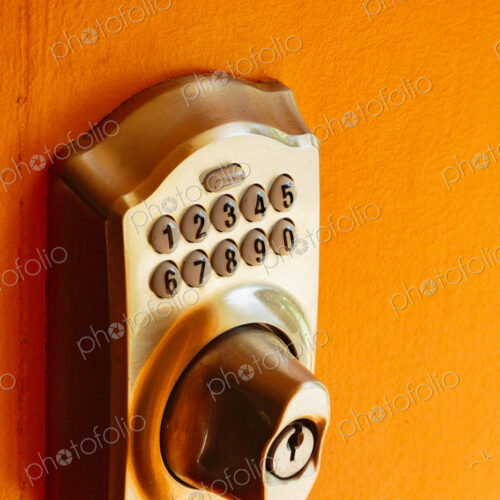 Electronic Door lock and key pad on an orange background, close up. Electronic Door lock and key pad on an orange background, close up.