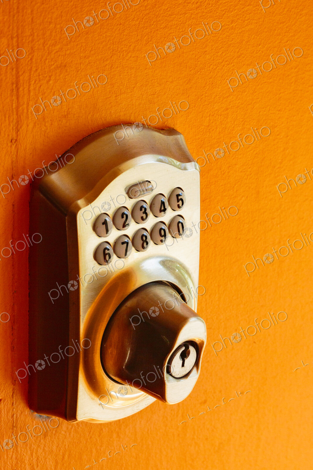 Electronic Door lock and key pad on an orange background, close up.