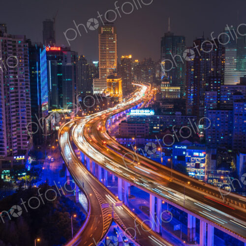 Elevated view of stacked road junction & Shanghai skyline at dusk, Shanghai, China