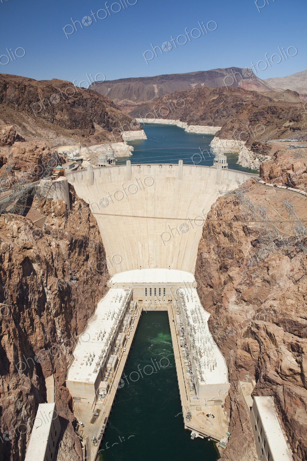 Elevated view of the Hoover Dam wall, buildings and the water pool at the base of the…