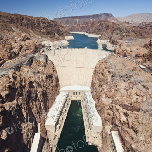 Elevated view of the Hoover Dam wall, buildings and the water pool at the base of the… Elevated view of the Hoover Dam wall, buildings and the water pool at the base of the…