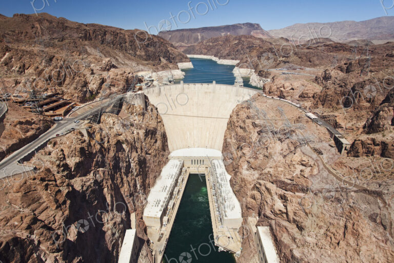 Elevated view of the Hoover Dam wall, buildings and the water pool at the base of the…