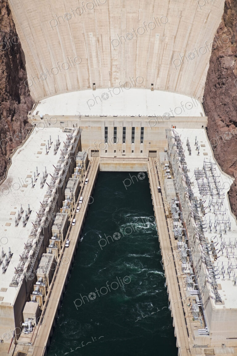 Elevated view of the Hoover Dam wall, buildings and the water pool at the base of the…