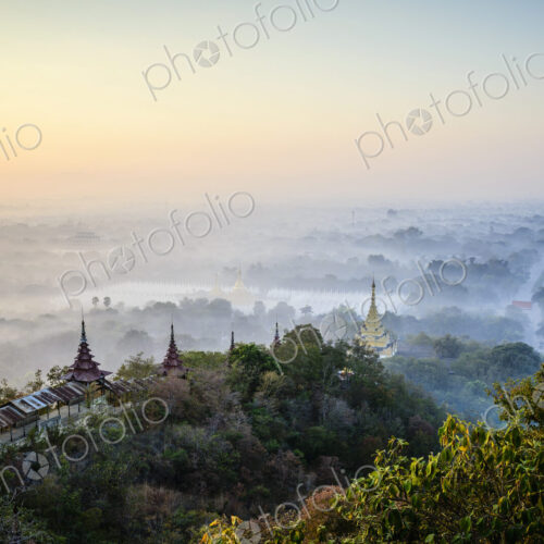Elevated view of the plain of temples in Mandalay, stupas and spires emerging from the… Elevated view of the plain of temples in Mandalay, stupas and spires emerging from the…
