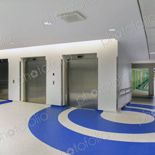 Elevators in the atrium of a new modern hospital, blue patterns on the floor Elevators in the atrium of a new modern hospital, blue patterns on the floor