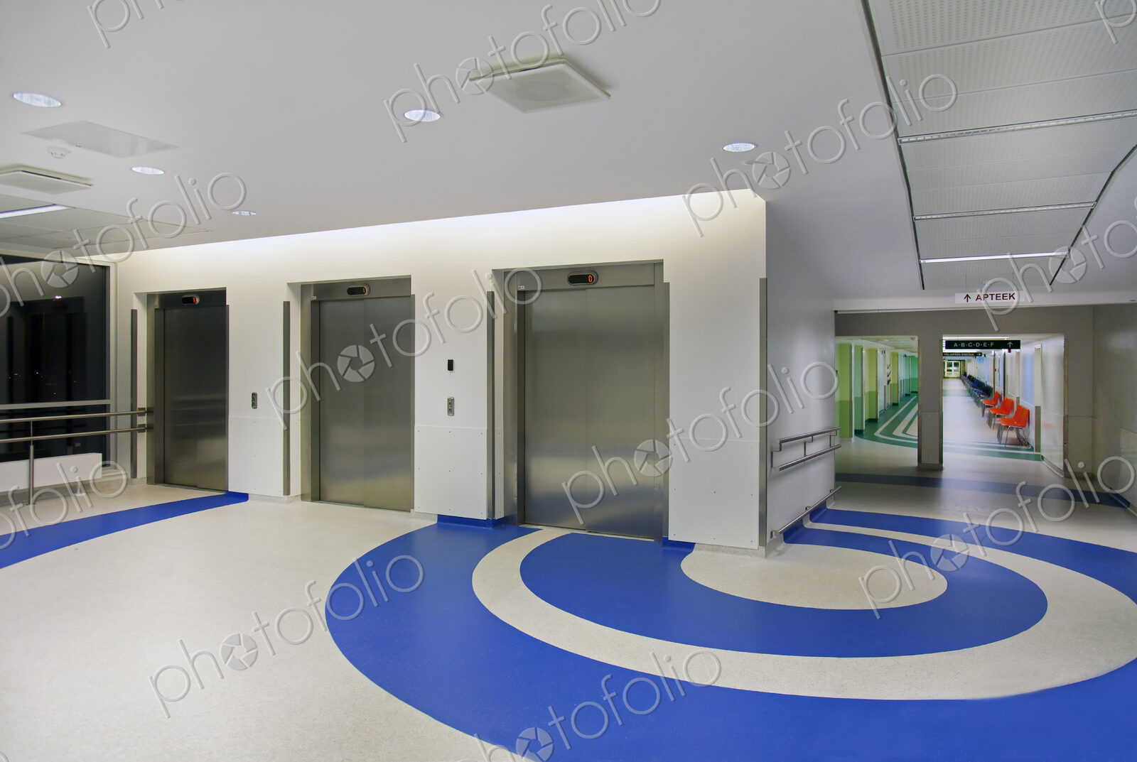 Elevators in the atrium of a new modern hospital, blue patterns on the floor