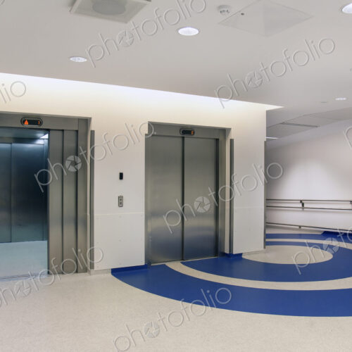 Elevators in the atrium of a new modern hospital, blue patterns on the floor Elevators in the atrium of a new modern hospital, blue patterns on the floor