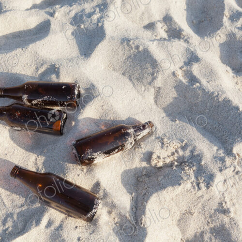 Empty abandoned beer bottles on beach Empty abandoned beer bottles on beach