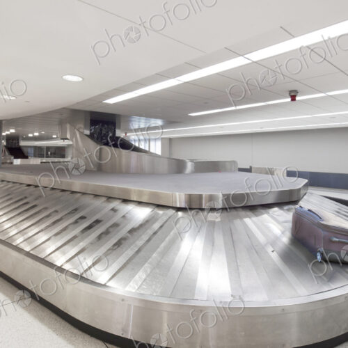 Empty airport luggage claim area, a single bag on a carousel. Empty airport luggage claim area, a single bag on a carousel.