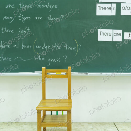 Empty chair at blackboard in classroom Empty chair at blackboard in classroom