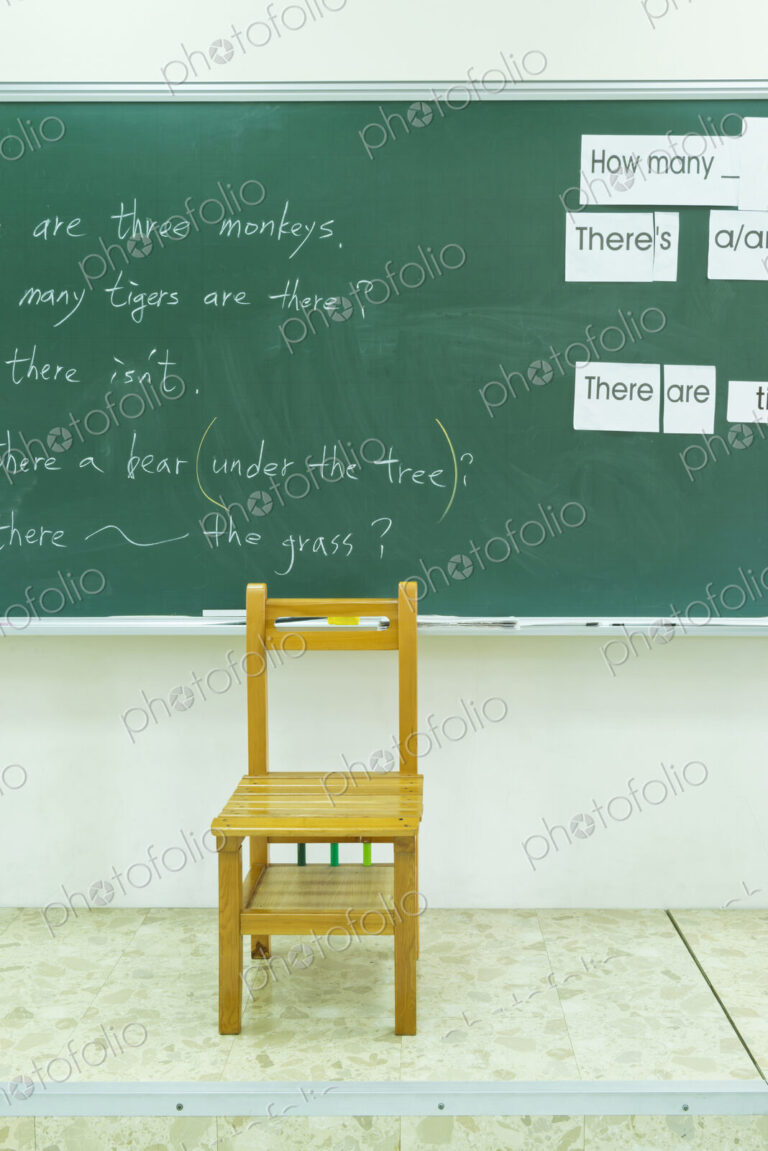 Empty chair at blackboard in classroom
