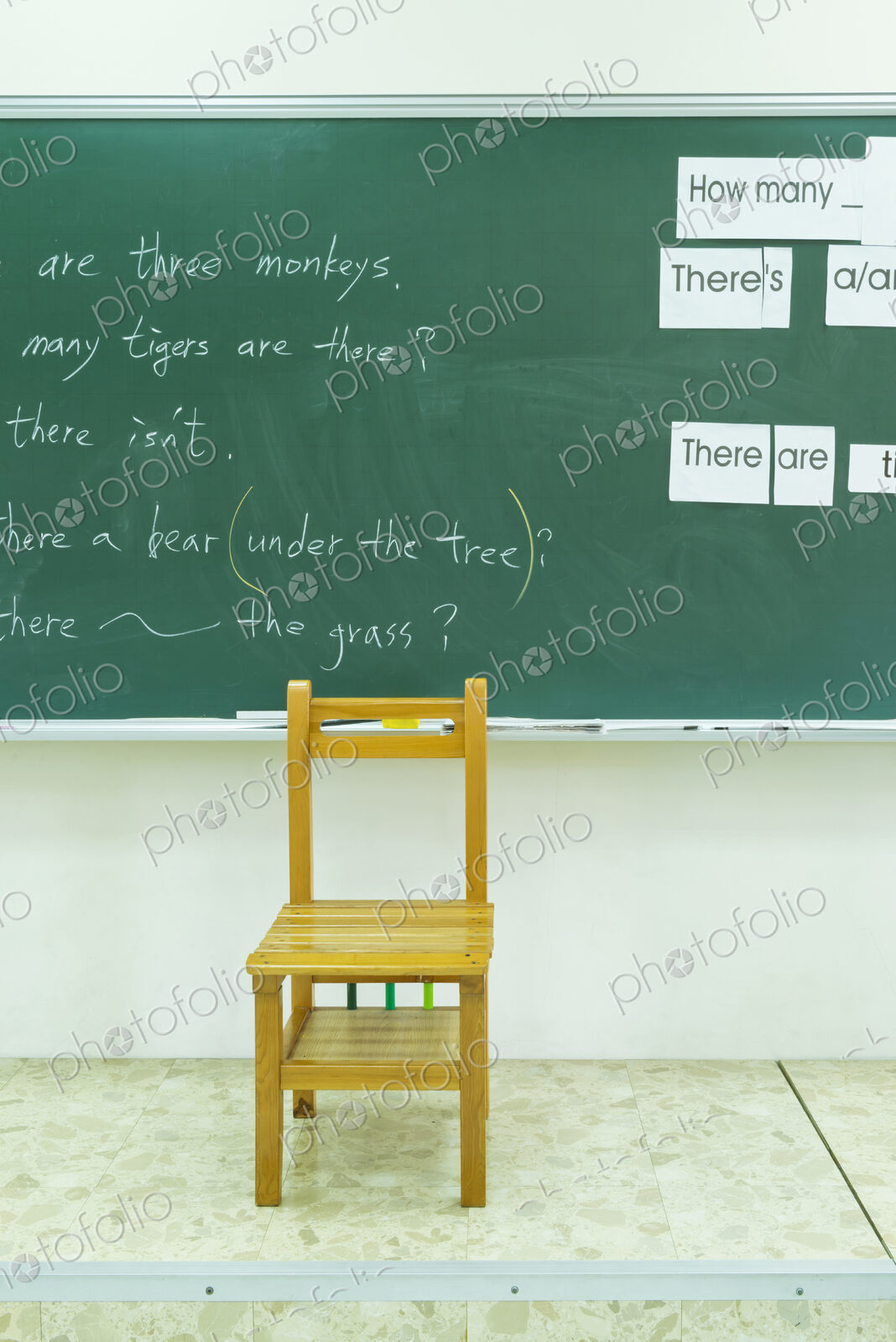 Empty chair at blackboard in classroom