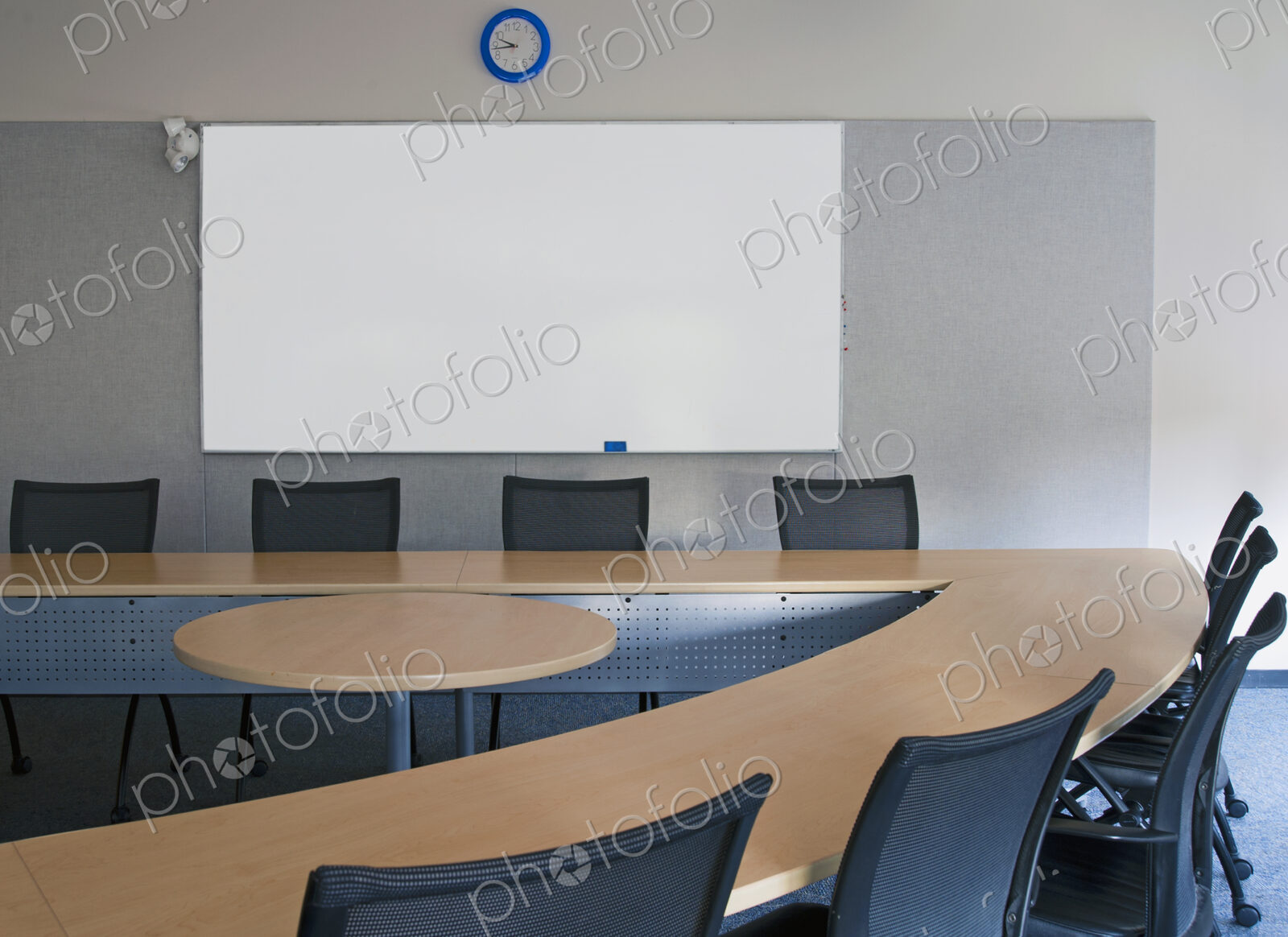 Empty meeting room in an office with triangular shaped table with a central space.