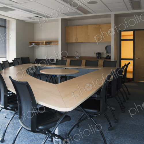 Empty meeting room in an office with triangular shaped table with a central space. Empty meeting room in an office with triangular shaped table with a central space.