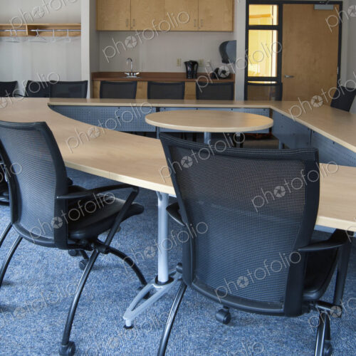 Empty meeting room in an office with triangular shaped table with a central space. Empty meeting room in an office with triangular shaped table with a central space.
