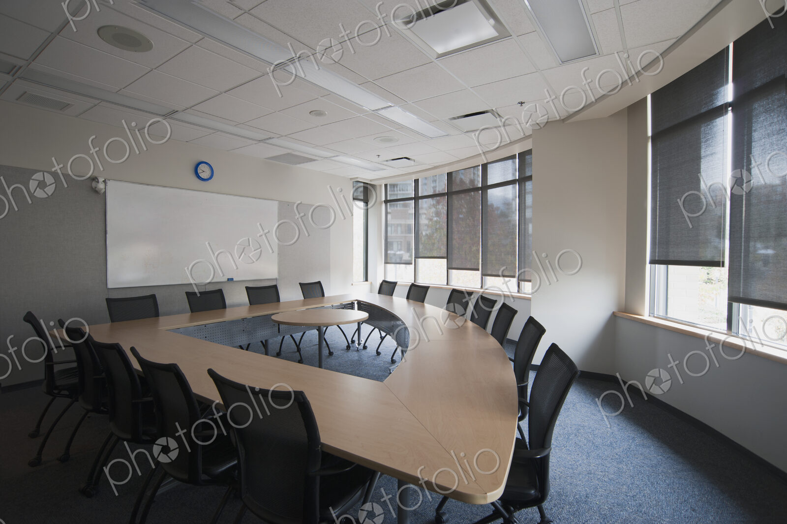 Empty meeting room in an office. A triangular shaped table with a central space. A…