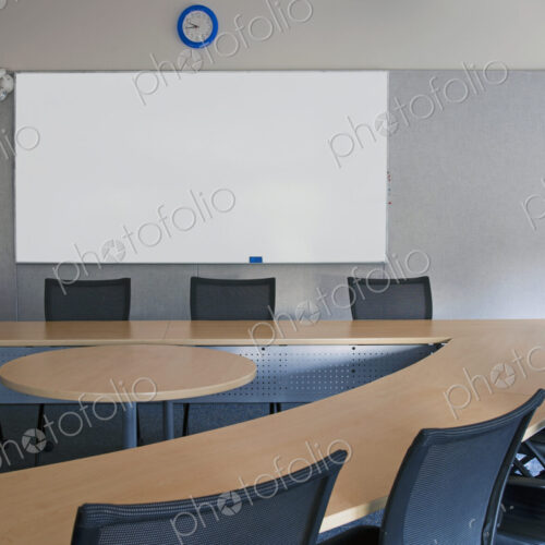 Empty meeting room in an office. A triangular shaped table with a central space. A…