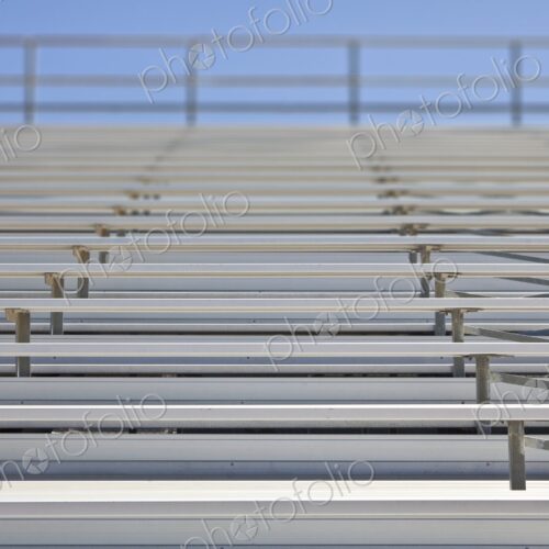 Empty metal stadium bleachers at a high school sports field. Empty metal stadium bleachers at a high school sports field.