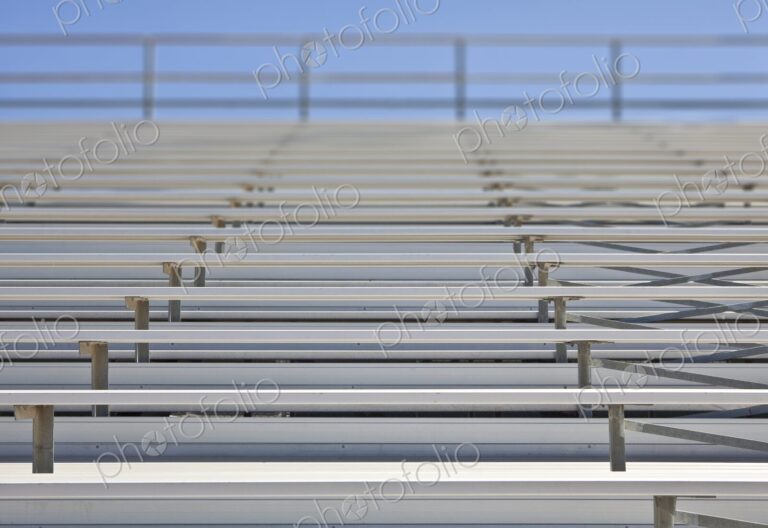 Empty metal stadium bleachers at a high school sports field.