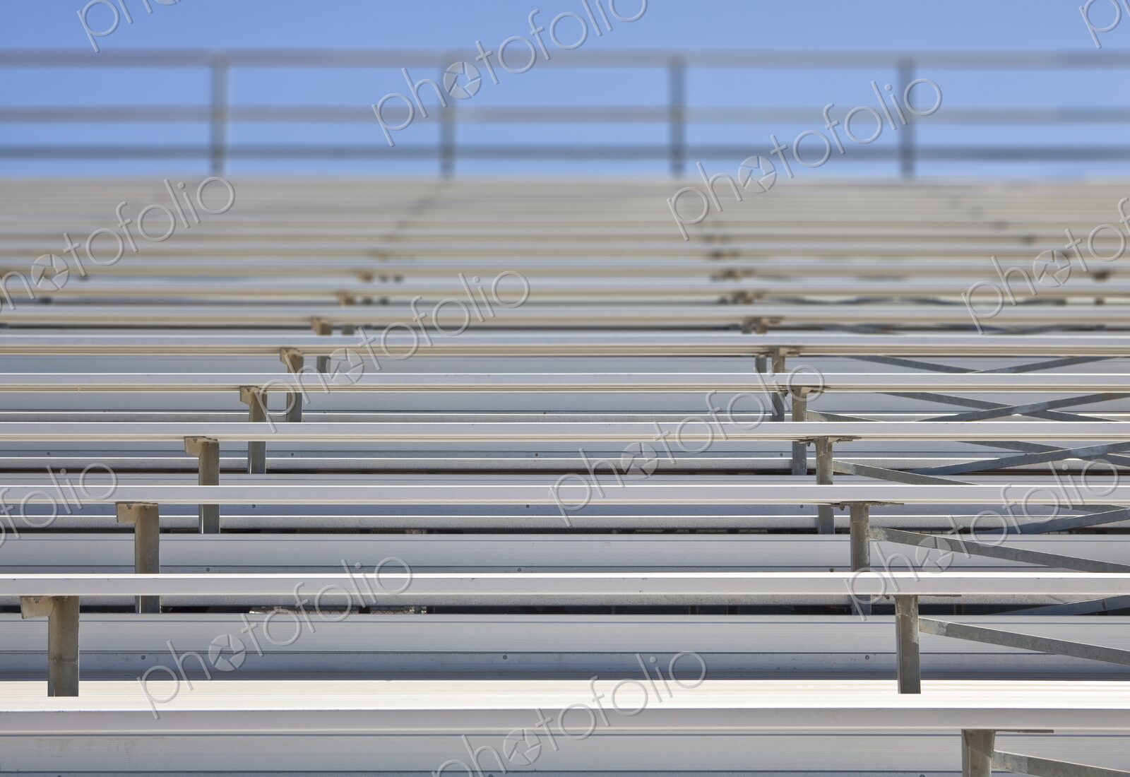 Empty metal stadium bleachers at a high school sports field.