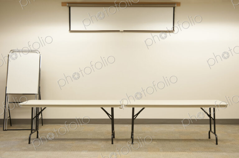 Empty tables under projector screen in classroom