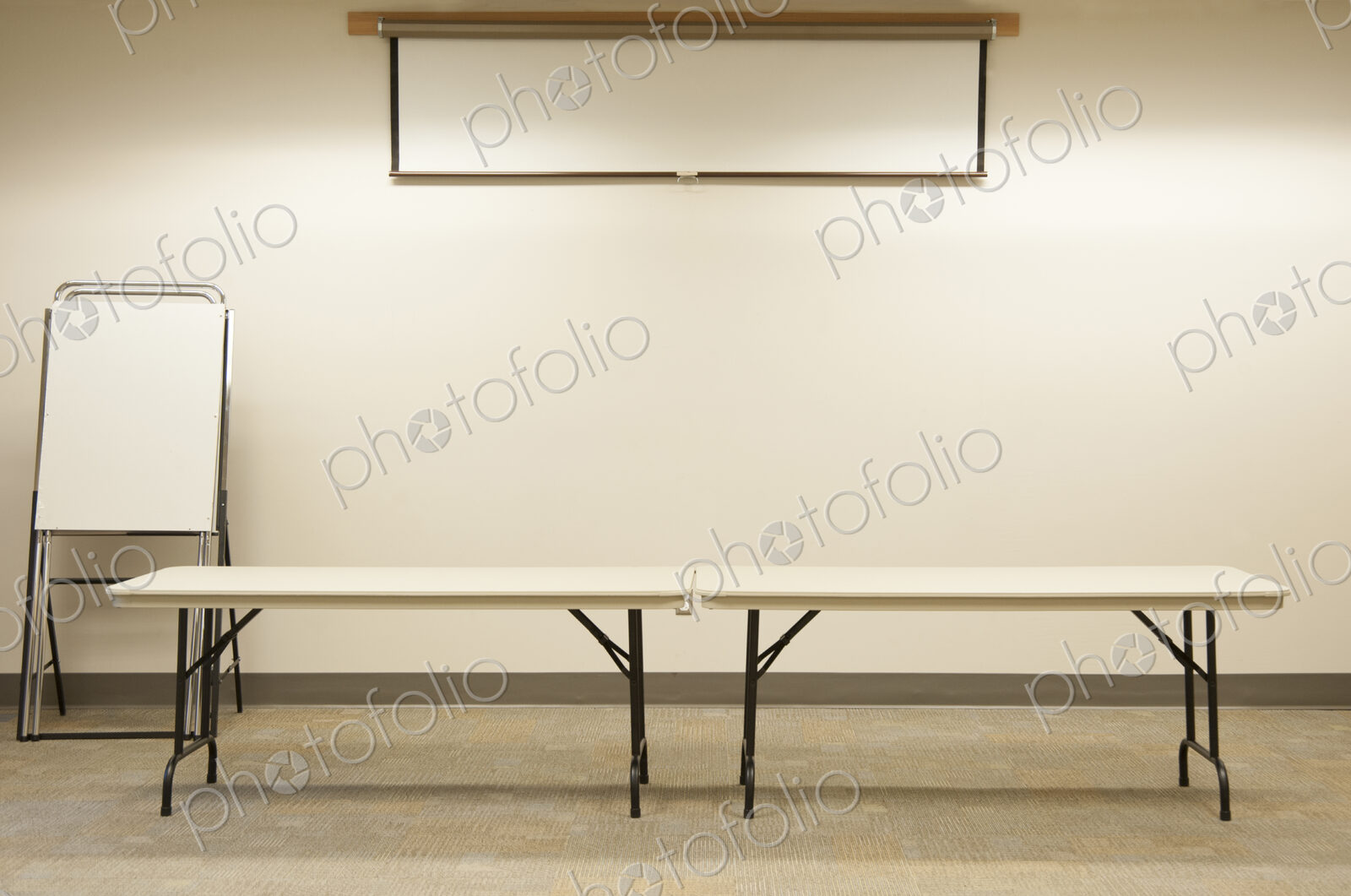 Empty tables under projector screen in classroom