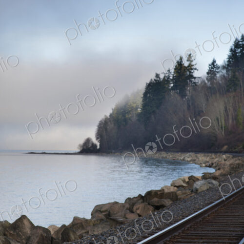 Empty train tracks around rural ocean bay