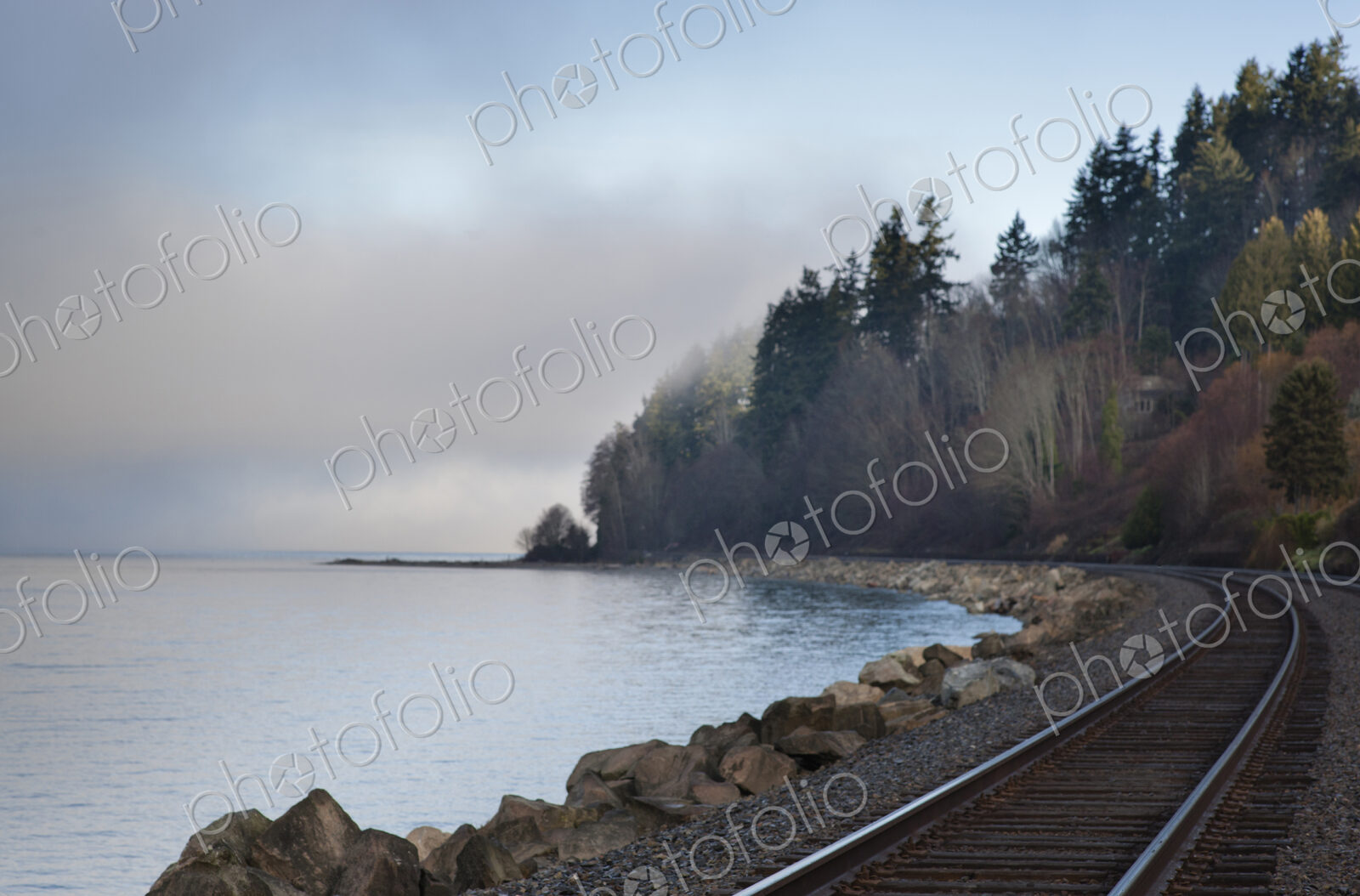 Empty train tracks around rural ocean bay