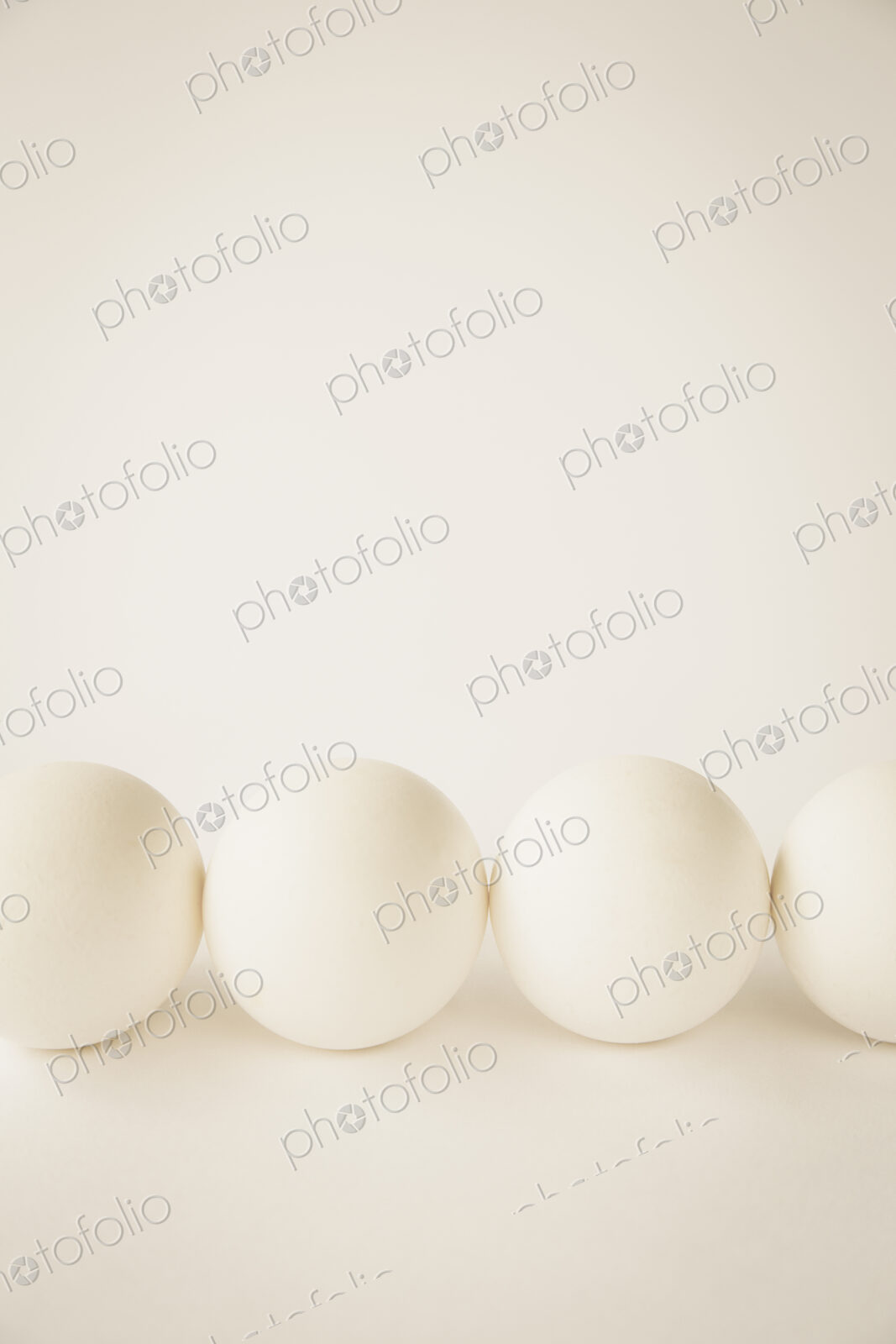 End-on view of free range, organic eggs with white shells arranged in a row, on a…