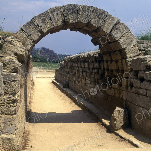 Entrance to the original Olympic Stadium at Olympia, an archway and stone walls Entrance to the original Olympic Stadium at Olympia, an archway and stone walls