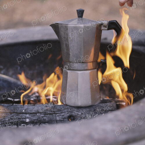 Espresso maker standing over an outdoor fire. Espresso maker standing over an outdoor fire.
