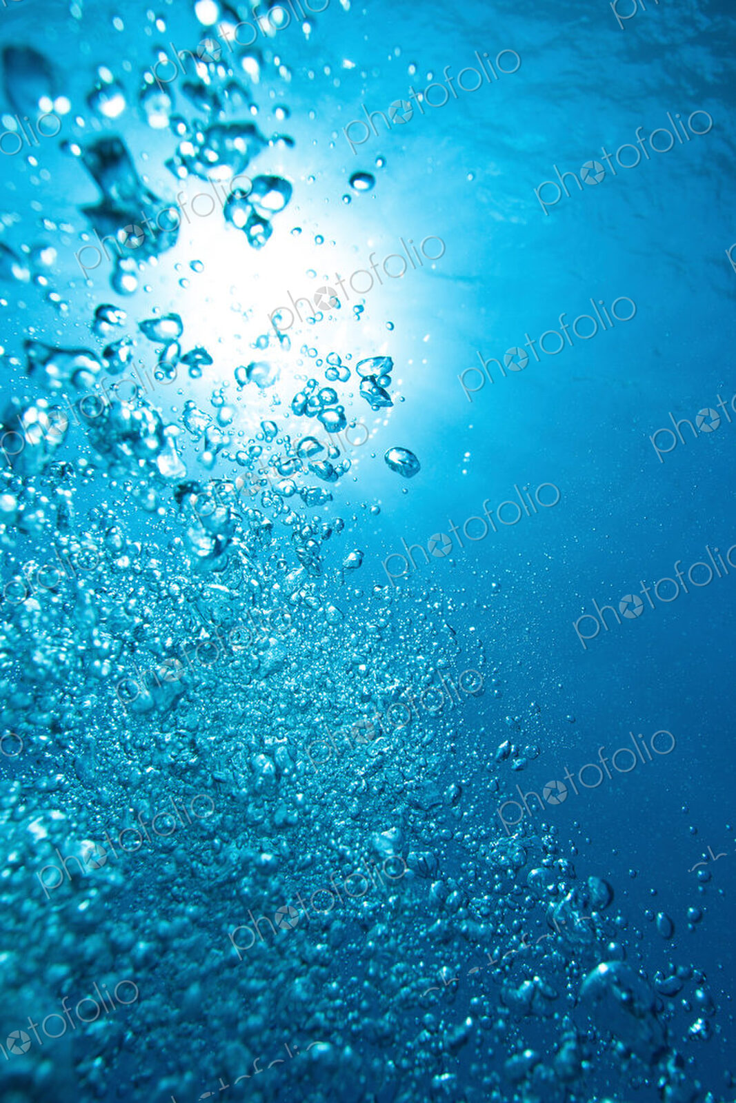 Exhaust bubbles from scuba diver rise towards the surface through water.