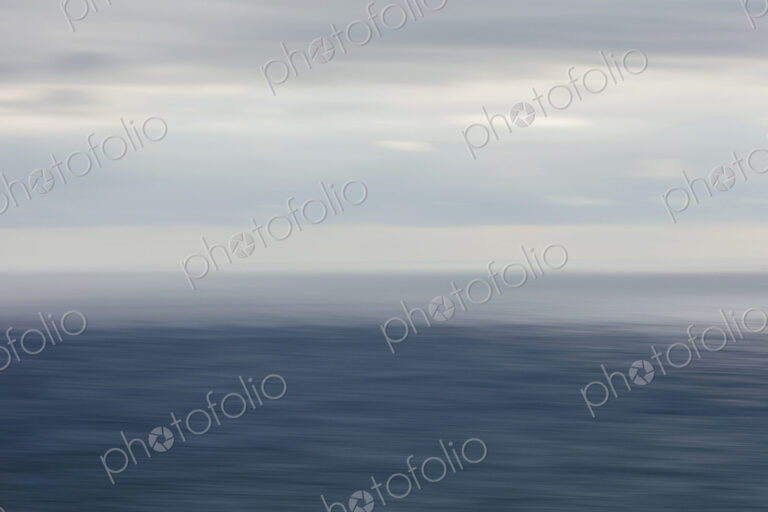 Expansive view of ocean, horizon and clearing storm clouds, dusk