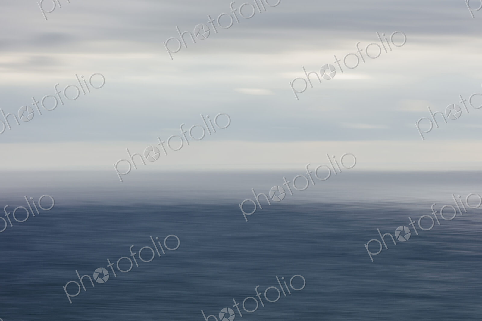 Expansive view of ocean, horizon and clearing storm clouds, dusk