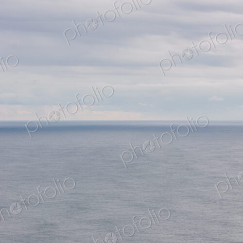 Expansive view of ocean, horizon and clearing storm clouds, dusk Expansive view of ocean, horizon and clearing storm clouds, dusk