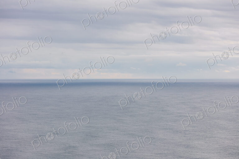 Expansive view of ocean, horizon and clearing storm clouds, dusk
