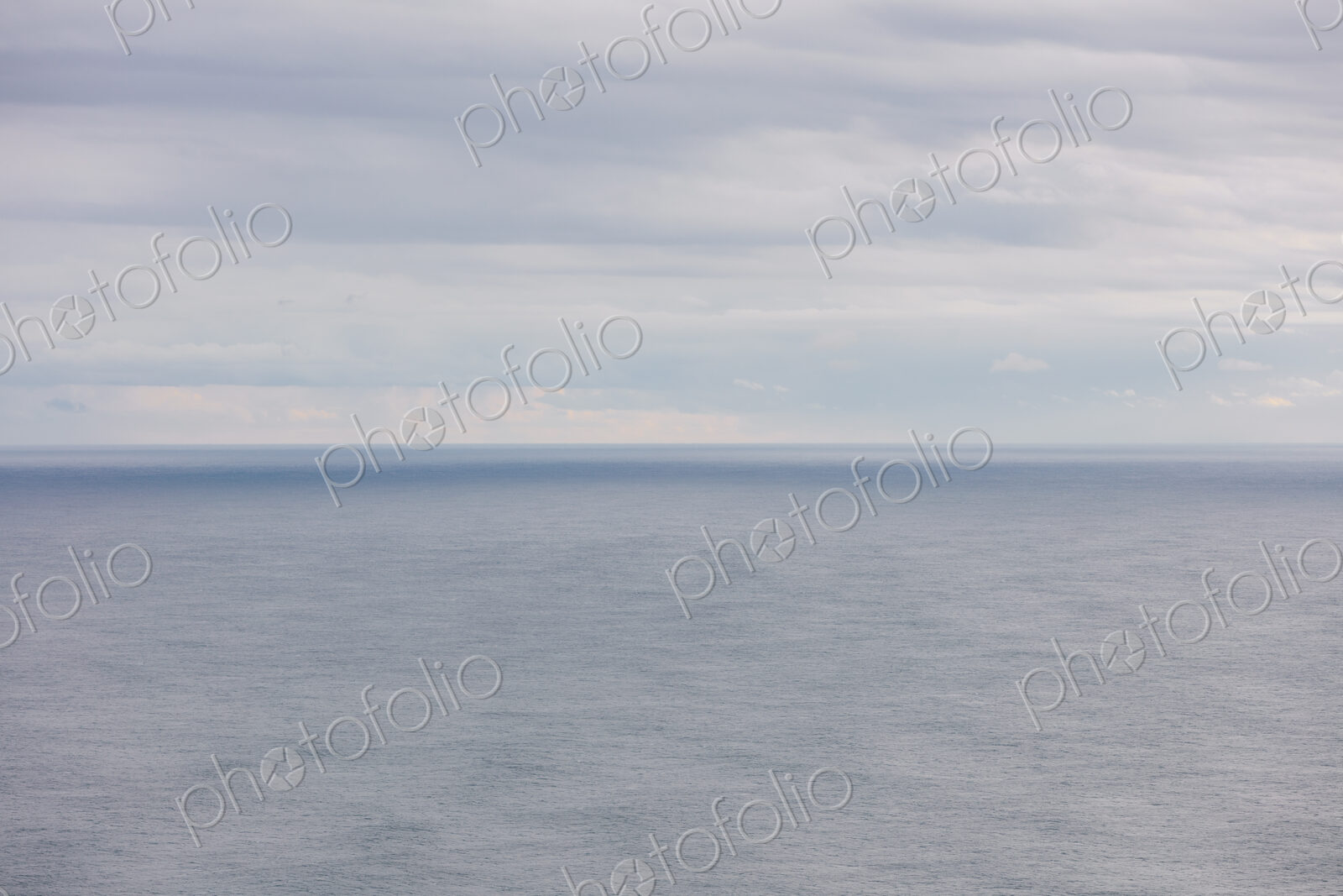 Expansive view of ocean, horizon and clearing storm clouds, dusk