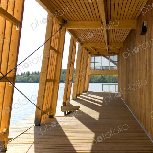 Exterior porch of wooden boathouse on river or waterfront.