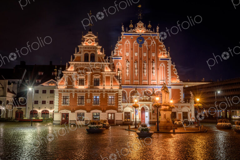 Exterior view of historic buildings on Town Hall Square in Riga at night.