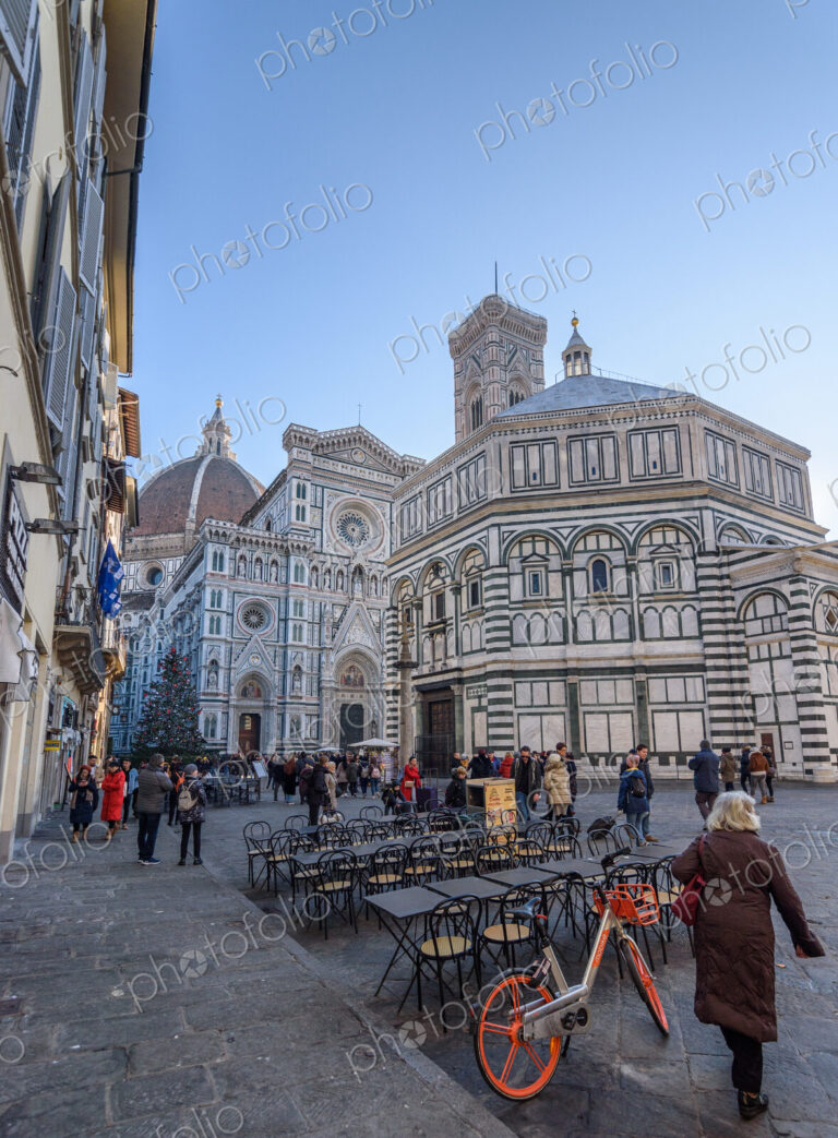 Exterior view of the Baptistery of St. John in Florence, people in the square below.