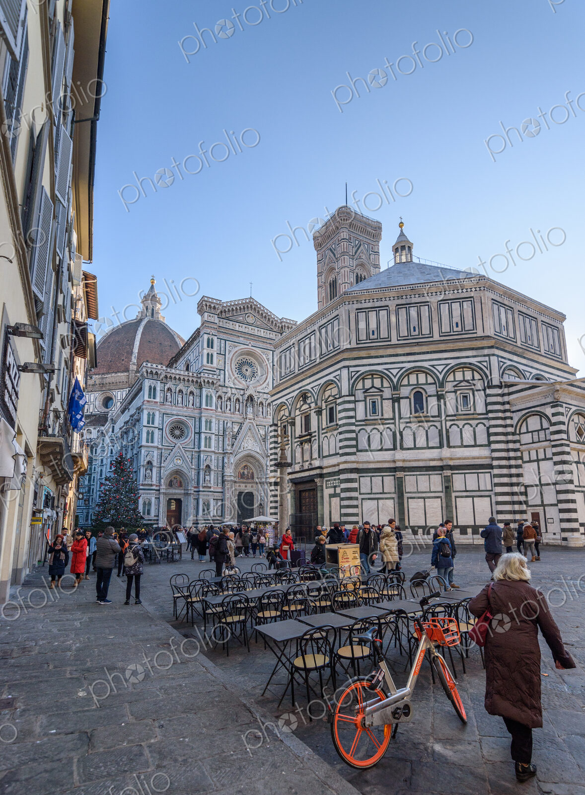 Exterior view of the Baptistery of St. John in Florence, people in the square below.